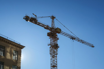 Crane and building construction site against blue sky