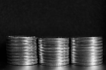 Piles of silver coins on a black background.
