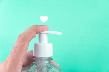 Man hand in container with alcohol gel on the light blue background