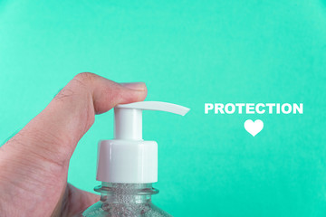 Man hand in container with alcohol gel on the light blue background