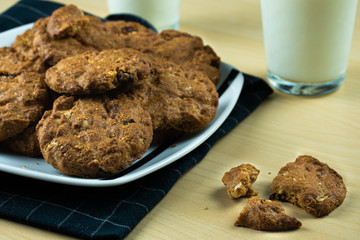 Cookies on a plate and glasses of milk in a wooden table