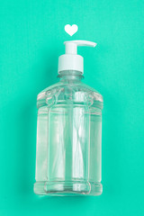 Container with alcohol gel on the light blue background