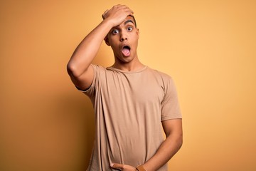 Young handsome african american man wearing casual t-shirt standing over yellow background...