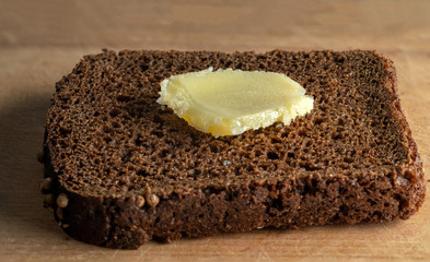 Ghee on a piece of coarse rye bread. Selective focus.