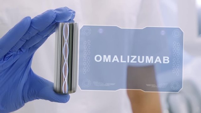 Hand in blue medical glove with a futuristic hud hologram with text Omalizumab. Medical concept of the technology of the future. Doctor with Futuristic Holographic Gadget