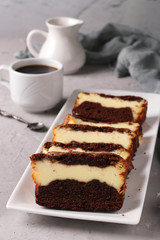 Sliced homemade chocolate muffin with cottage cheese located on a white plate on gray background, Vertical format