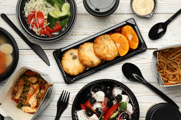 Food delivery. Food in takeaway boxes on wooden table