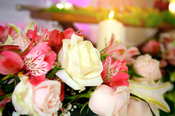 Candles are burning on the table, next to white and pink flowers. Wedding interior decor table decoration in a restaurant.