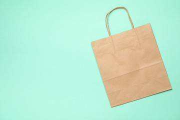 Blank paper bag on mint background, space for text