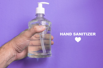 Man hand in container with alcohol gel on the light blue background