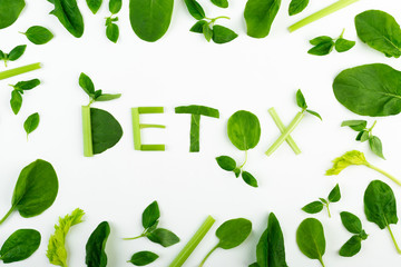 Word Detox collected from a variety of fresh organic plants such as mint,, spinach, celery on a white background.