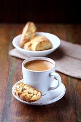 Cup of coffee with cantuccini  (Italian cookies) on rustic wooden background. 