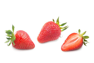 Ripe fresh organic strawberries and half a strawberry with leaves isolated on white background