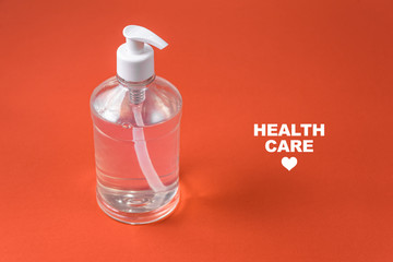 Container with alcohol gel on the red background