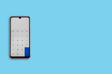 Calculator on the phone on one side, on blue background. Calculator.