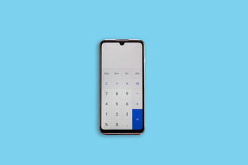 Calculator on the phone on blue background. Calculator.