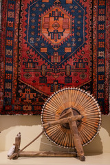 Traditional devices, vintage tailoring equipment concept. Old rug, fashioned wooden distaff, spindle, spinning wheel