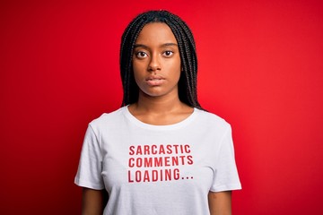 Young african american woman wearing sarcasm coments text on t-shirt over red background with a...