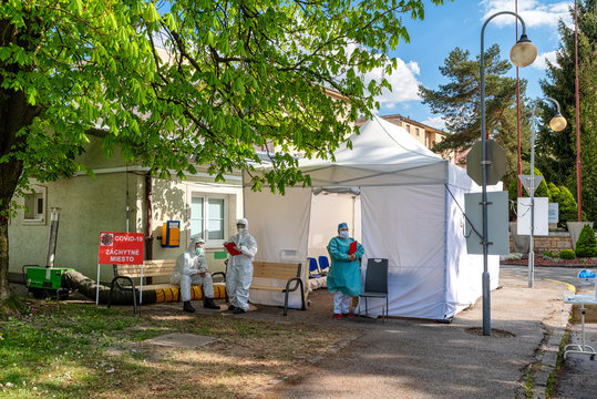 Doctors in protective suits and shields in front of tent waiting