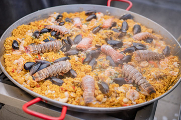 Paella de mariscos, plato con camarones, langosta, langostinos, almejas, arroz y verduras 