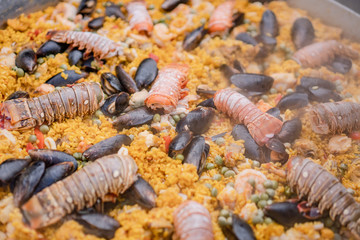 Paella de mariscos, plato con camarones, langosta, langostinos, almejas, arroz y verduras 