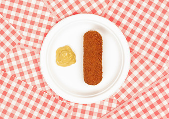 Brown crusty dutch kroket with mustard on a white plate isolated