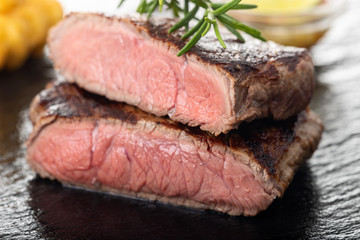 slices of grilled steak on black slate