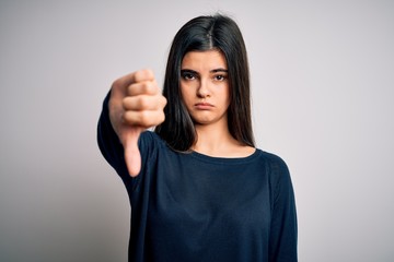 Young beautiful brunette woman wearing casual sweater standing over white background looking...