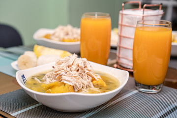 Ajiaco Santafereño, plato tipico colombiano, comida típica del interior de Colombia acompañado de jugo de mango 