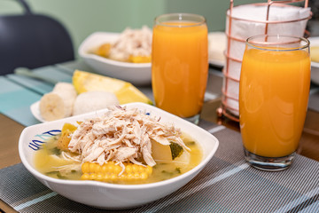 Ajiaco Santafereño, plato tipico colombiano, comida típica del interior de Colombia acompañado de jugo de mango 