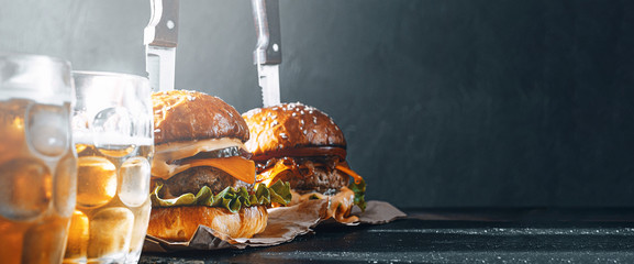 two delicious beef burger on a wooden table near two glass of cold beer - Powered by Adobe