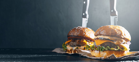 Two mouth-watering, delicious homemade burger used to chop beef. on the wooden table. The burgers...