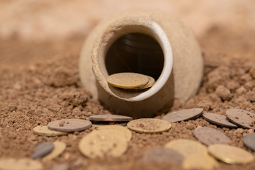 Antique coins in an ancient pottery jug. Old mesopotamia money. The treasure. Antique cracked...