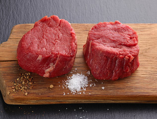 Raw beef steak on wooden board