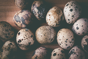 Quail eggs on a wooden background. Tinted photo