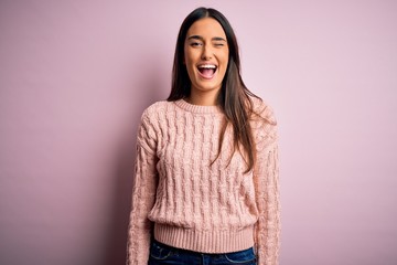Fototapeta premium Young beautiful brunette woman wearing casual sweater over isolated pink background winking looking at the camera with sexy expression, cheerful and happy face.