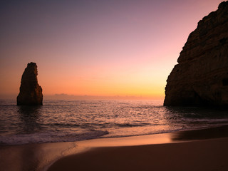 Sunset in front of the big lonely rock. Algarve, Portugal.