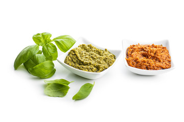 Green basil and red tomato pesto dip sauce  and basil leaves.