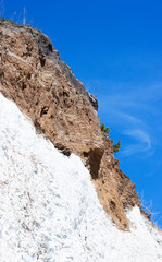 a steep vertical slope of white rock and clay