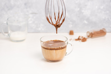 Dalgona cocoa coffee with ice and creamy whipped instant coffee on wooden tray. Trend korean drink latte on marble table
