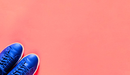 Blue sneakers for Remote Workouts or Working out from home on pink background. Calming Simplicity and Sustainable health for quarantine