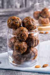 Energy balls of dried fruits and nuts in a glass jar, sellective focus on background.
