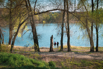 Young guys with bicycles by the lake in the park