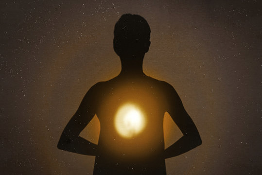 Female silhouette radiating light from within a spiritual heart opening.