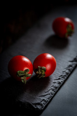Red fresh healthy tomatoes isolated on a black surface