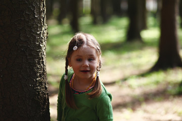happy little girl walking in the spring forest