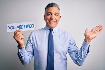 Middle age grey-haired man fired with problems holding paper with you are fired message very happy and excited, winner expression celebrating victory screaming with big smile and raised hands