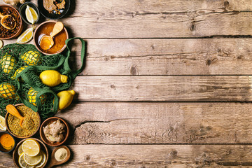 Ingredients for healthy hot drink. Lemon, ginger, honey, and turmeric in a bowls on a wooden background. Ambrosia, pollen and propolis in a bowls. Alternative medicine concept. Clean eating, detox.