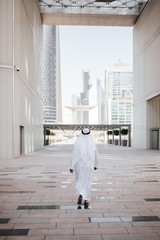 Emirates urban lifestyle in the big city with Arab guy investor checking out the city in gulf country. Photography of Arabian places and building construction.