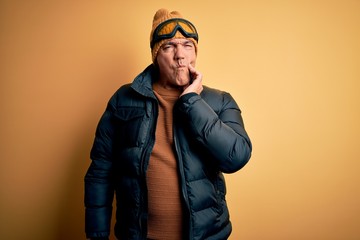 Middle age handsome grey-haired skier man on vacation wearing ski goggles touching mouth with hand with painful expression because of toothache or dental illness on teeth. Dentist